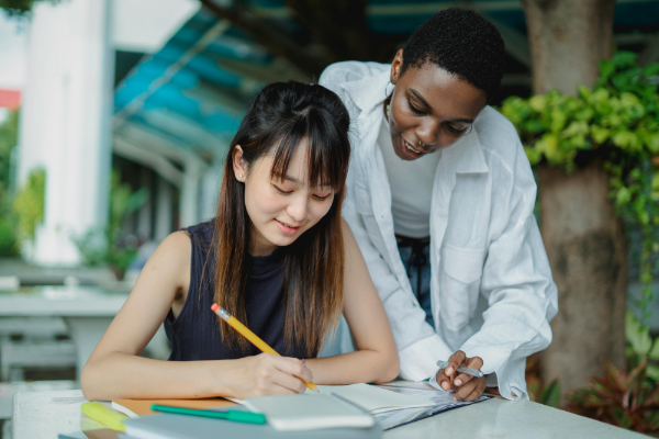 A teacher looks at the work a teenaged student has completed